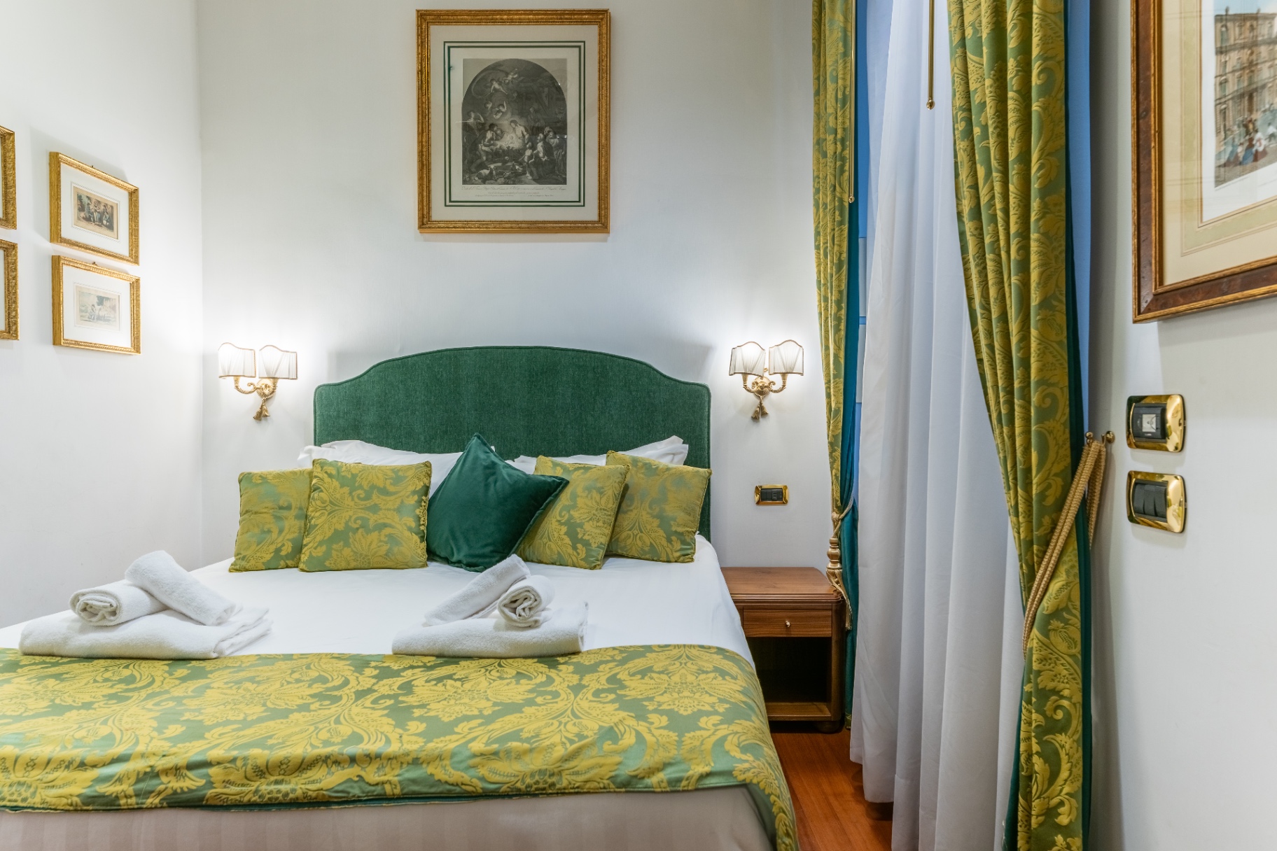 Camera da letto con testiera verde e tessuti damascati